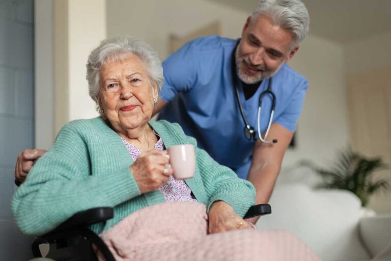 Residents of various backgrounds sharing a meal together in a comfortable, well-lit common dining area.